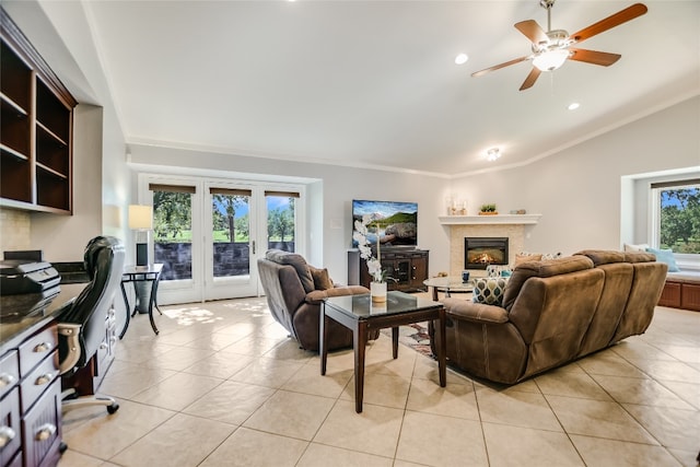 tiled living room with ceiling fan, lofted ceiling, crown molding, and french doors