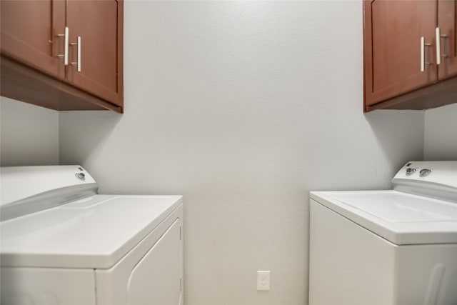 laundry area featuring washer and dryer and cabinets