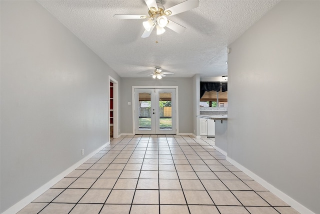 empty room with ceiling fan, a textured ceiling, and french doors