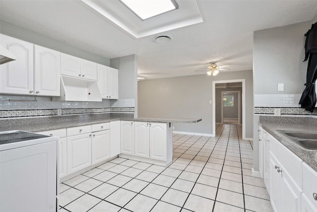 kitchen featuring sink, white cabinets, kitchen peninsula, light tile patterned floors, and ceiling fan