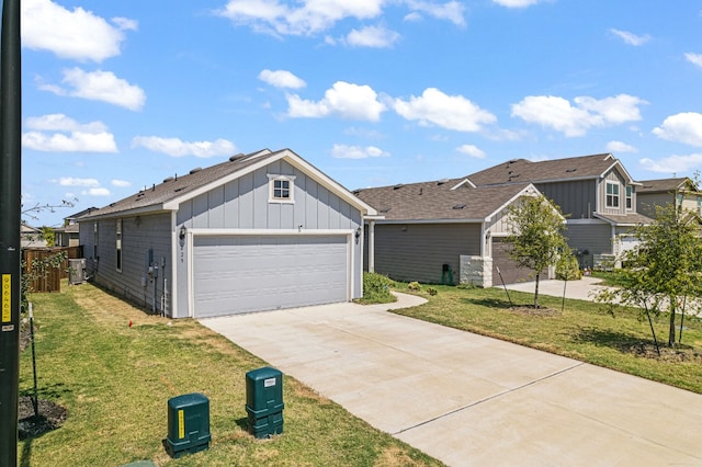 view of front of house with a garage, central AC, and a front yard