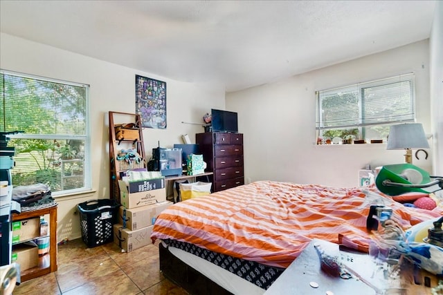 bedroom with multiple windows and light tile patterned floors