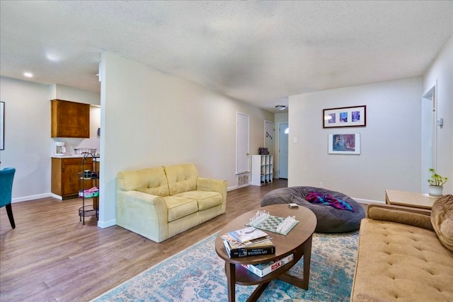 living room featuring a textured ceiling and light hardwood / wood-style floors