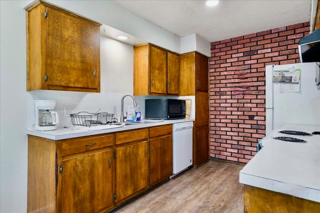 kitchen with white appliances, brick wall, a textured ceiling, exhaust hood, and light hardwood / wood-style floors