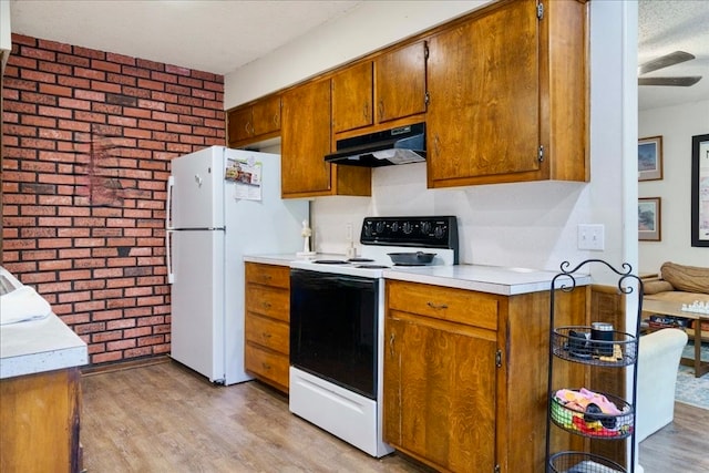 kitchen featuring brick wall, light hardwood / wood-style flooring, white appliances, and ceiling fan