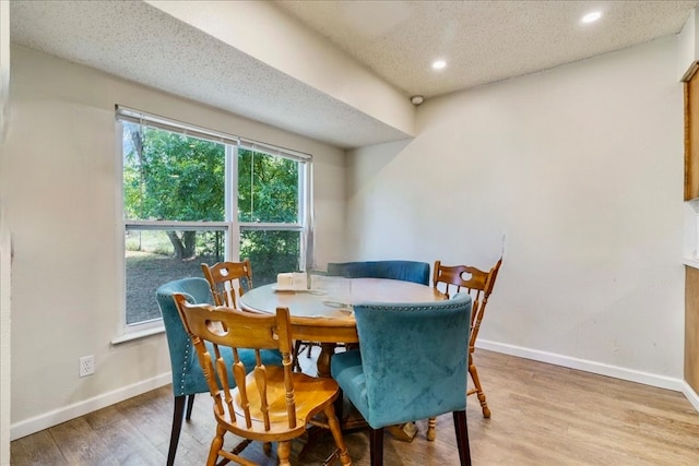 dining area featuring a textured ceiling and wood-type flooring