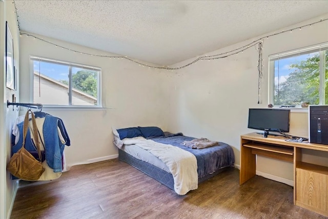 bedroom with a textured ceiling and dark wood-type flooring