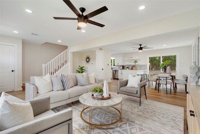 living room featuring ceiling fan and light hardwood / wood-style flooring