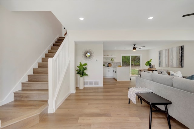 living room featuring light hardwood / wood-style floors and ceiling fan