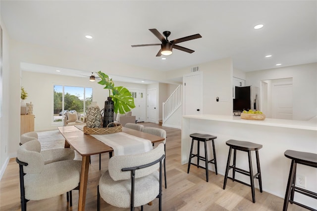 dining area with ceiling fan and light hardwood / wood-style floors