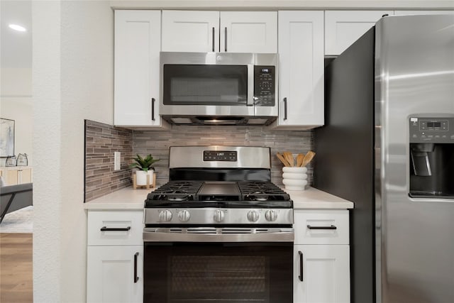 kitchen with white cabinets, appliances with stainless steel finishes, and tasteful backsplash