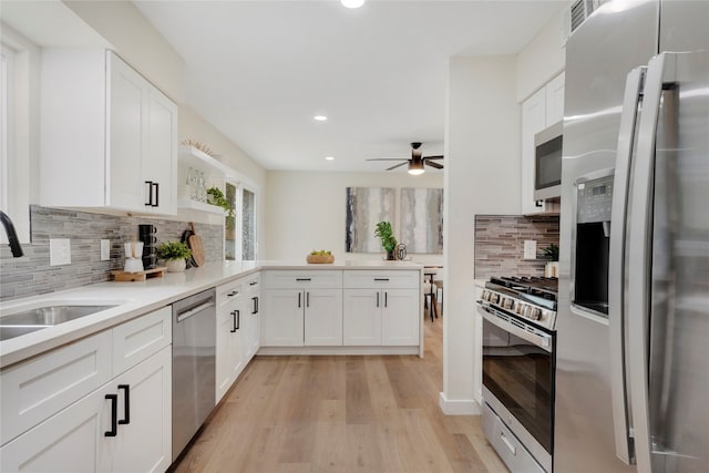 kitchen featuring ceiling fan, white cabinets, appliances with stainless steel finishes, and light hardwood / wood-style flooring