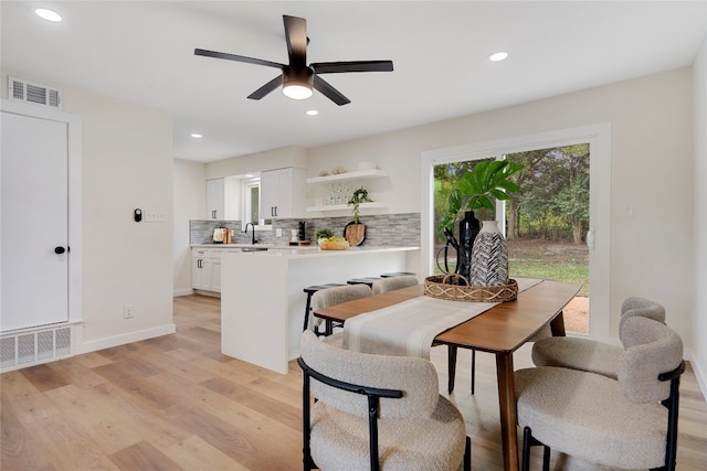 dining space featuring ceiling fan, light wood-type flooring, and sink