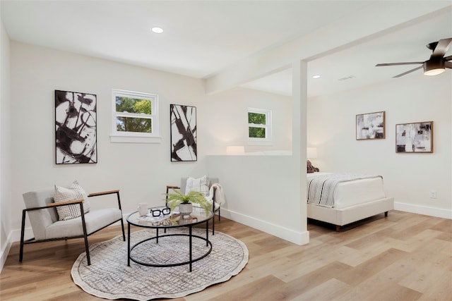 bedroom with beam ceiling, light hardwood / wood-style floors, and ceiling fan