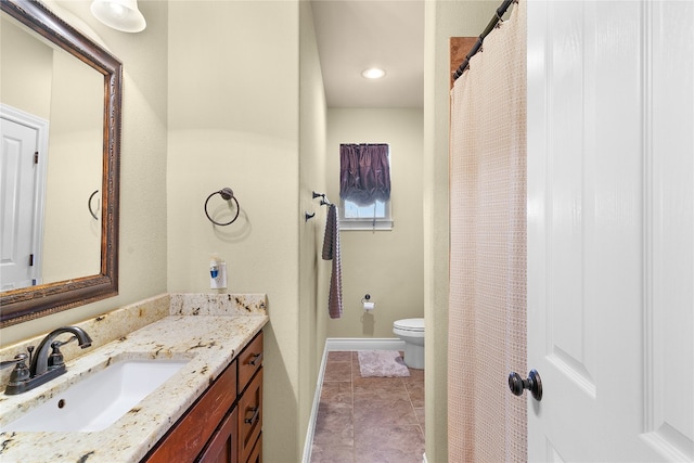 bathroom with tile patterned flooring, vanity, and toilet