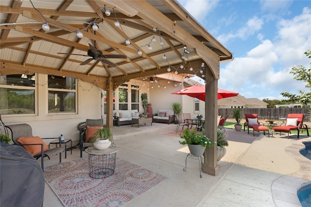 view of patio featuring outdoor lounge area, ceiling fan, and a gazebo