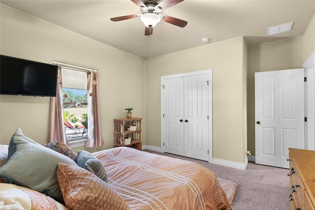 bedroom featuring a closet, light colored carpet, and ceiling fan