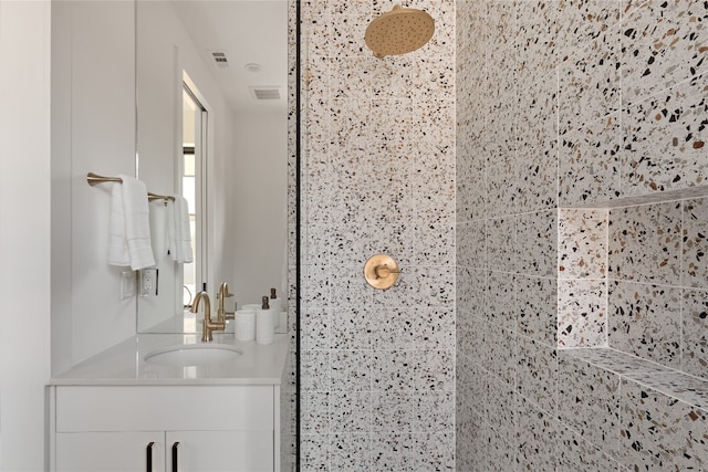 bathroom with vanity and tiled shower