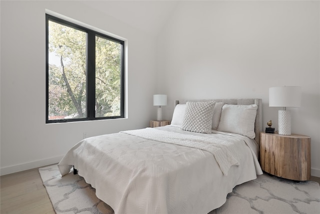 bedroom featuring vaulted ceiling and light wood-type flooring