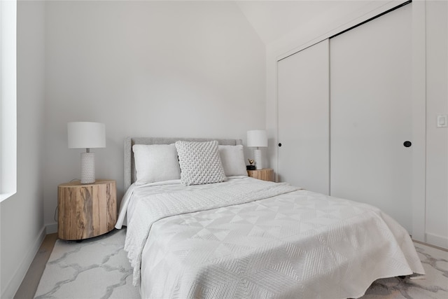 carpeted bedroom featuring a closet and lofted ceiling