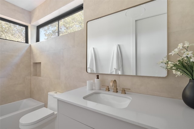 full bathroom with shower / bathing tub combination, vanity, toilet, and tile walls