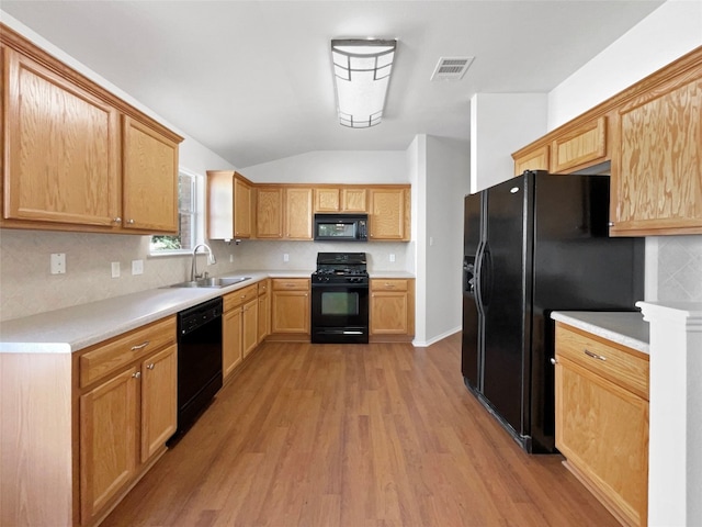 kitchen with light hardwood / wood-style flooring, sink, lofted ceiling, and black appliances