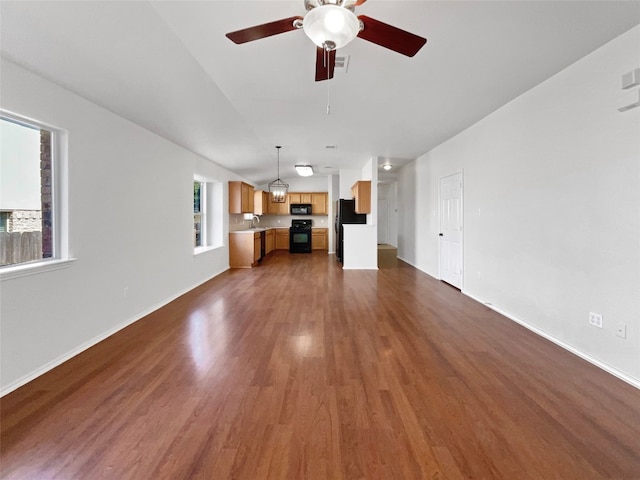 unfurnished living room featuring ceiling fan, sink, and dark hardwood / wood-style flooring