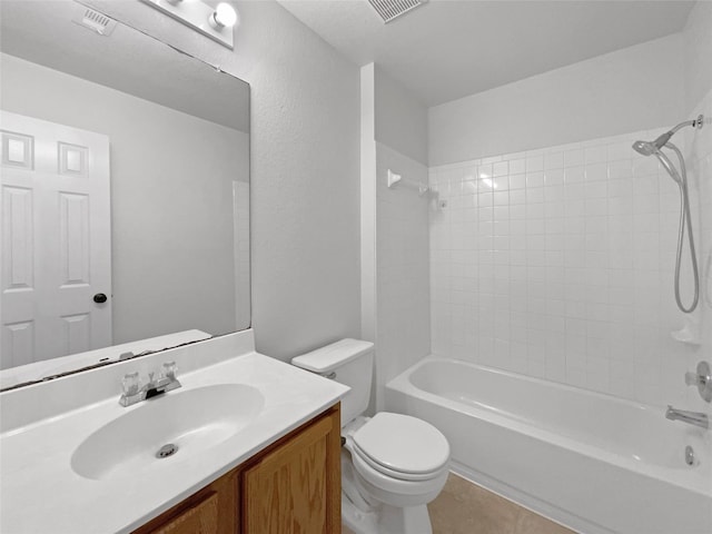 full bathroom featuring tiled shower / bath, vanity, tile patterned flooring, and toilet