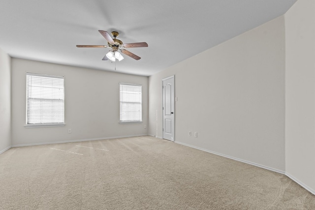 carpeted empty room featuring a wealth of natural light and ceiling fan