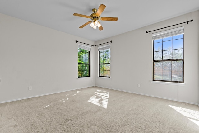 carpeted spare room featuring ceiling fan