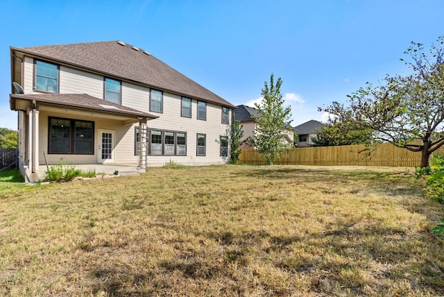 rear view of property with a lawn