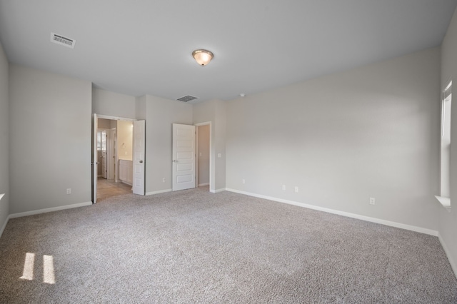 unfurnished bedroom with ensuite bathroom and light colored carpet