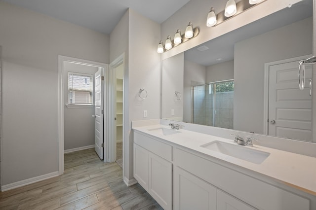 112 Driftwood Hills Way, Georgetown, TX 78633 - bathroom featuring a tile shower, healthy amount of natural light, wood finished floors, and double vanity