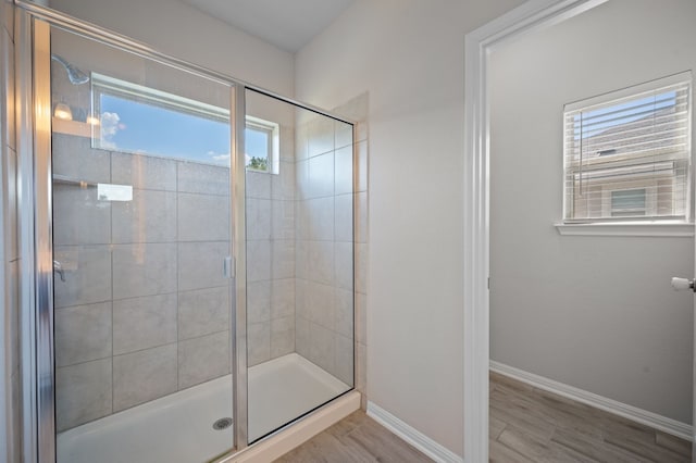 bathroom featuring hardwood / wood-style floors, an enclosed shower, and plenty of natural light