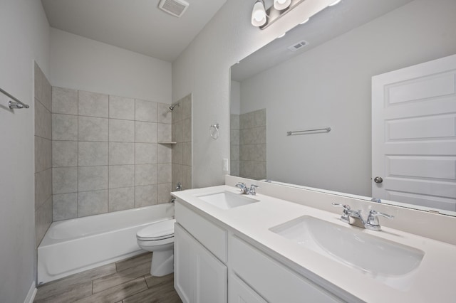 full bathroom with toilet, vanity, and tiled shower / bath combo