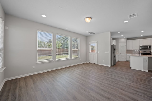 unfurnished living room with dark wood-type flooring