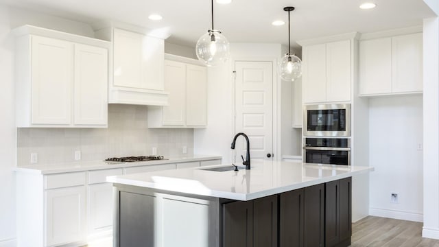 kitchen featuring backsplash, stainless steel oven, a sink, gas cooktop, and built in microwave