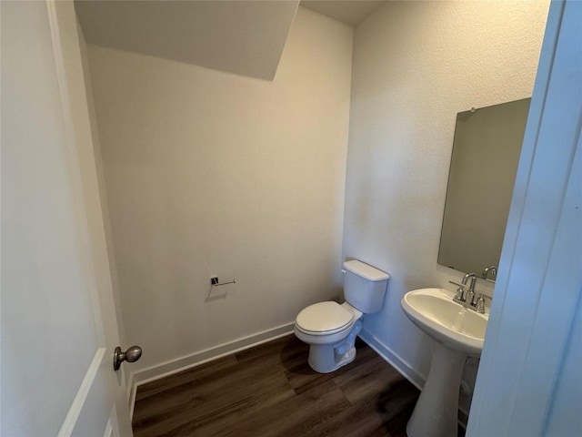 bathroom with hardwood / wood-style flooring, toilet, and sink