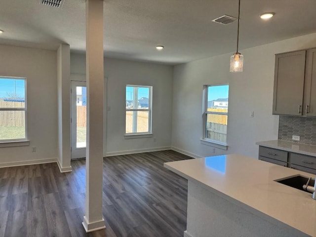 kitchen featuring decorative backsplash, gray cabinets, plenty of natural light, and decorative light fixtures