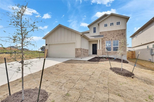 view of front of home with fence, driveway, an attached garage, brick siding, and board and batten siding