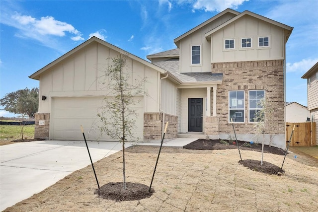 view of front facade featuring fence, board and batten siding, concrete driveway, an attached garage, and brick siding