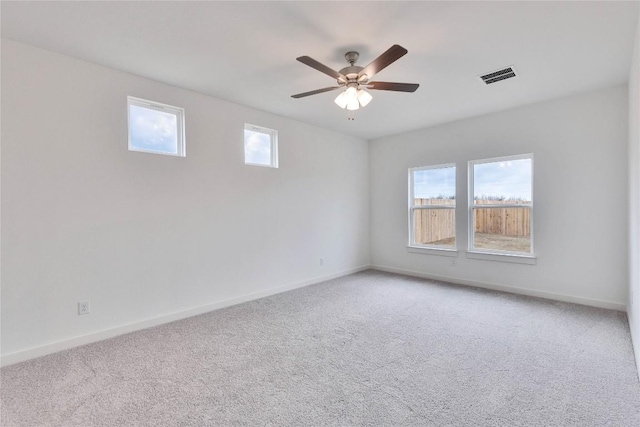 unfurnished room featuring visible vents, light colored carpet, baseboards, and ceiling fan