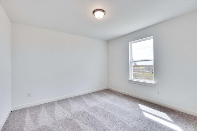 carpeted empty room with baseboards