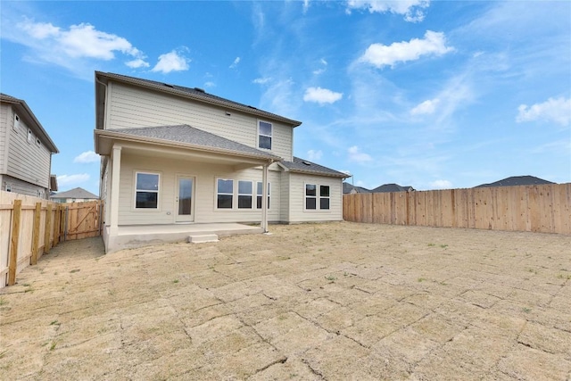 rear view of house featuring a patio and a fenced backyard