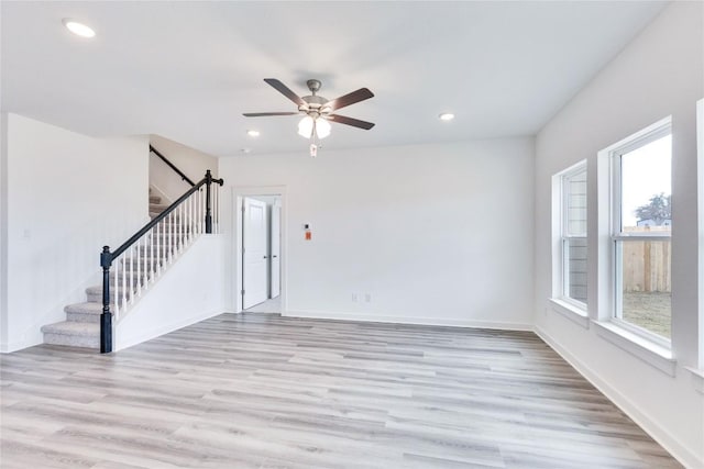 unfurnished living room with recessed lighting, light wood-style flooring, stairs, and baseboards