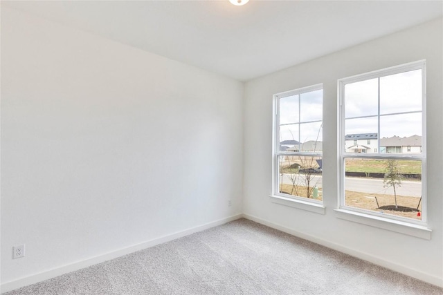 carpeted spare room with baseboards