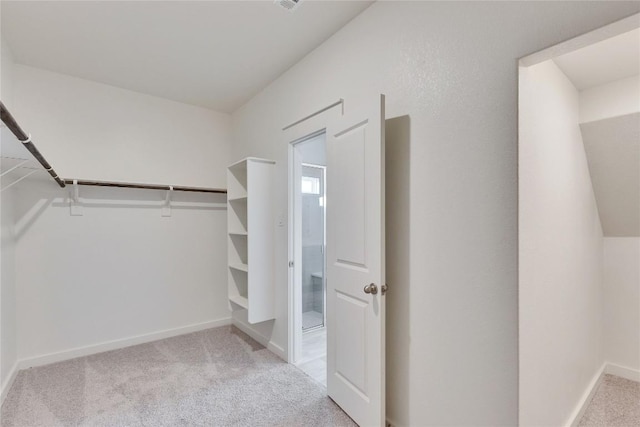 walk in closet featuring light colored carpet