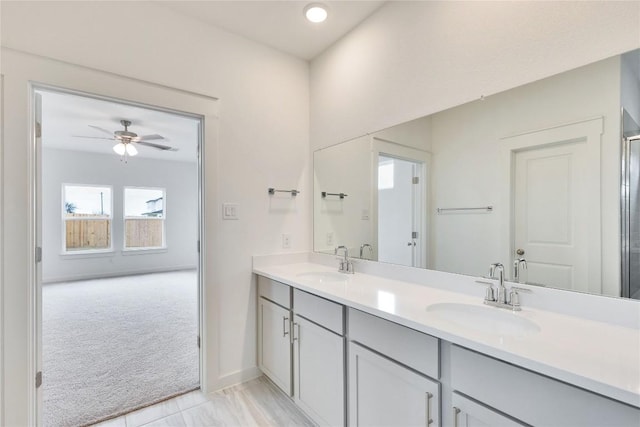 bathroom with double vanity, a ceiling fan, baseboards, and a sink