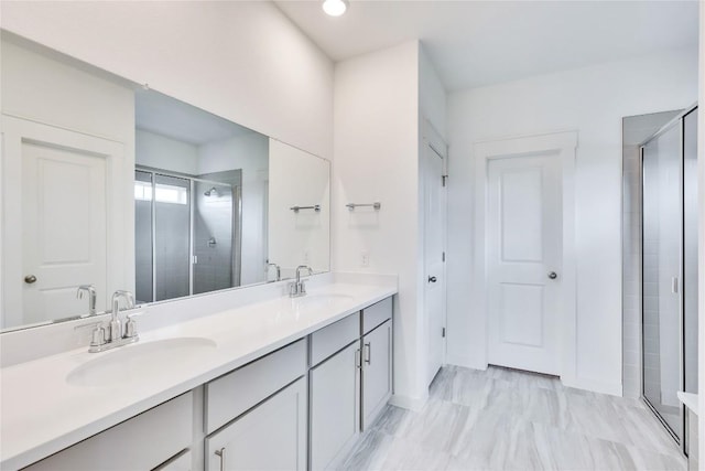 bathroom with a sink, double vanity, and a shower stall