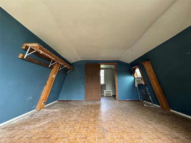 unfurnished living room with cooling unit, vaulted ceiling, and parquet floors